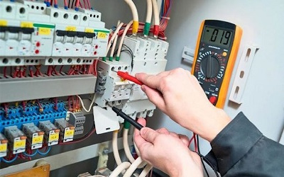 Trabajador probando térmica electromagnética en el tablero eléctrico